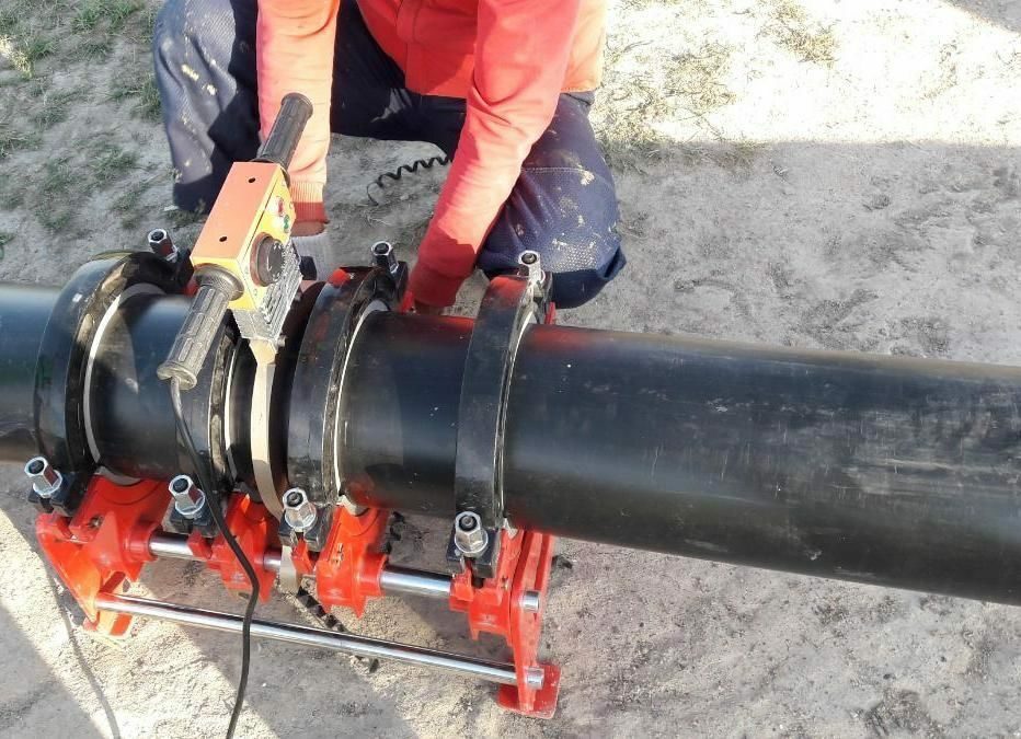 Man conducts welding of polyethylene pipes